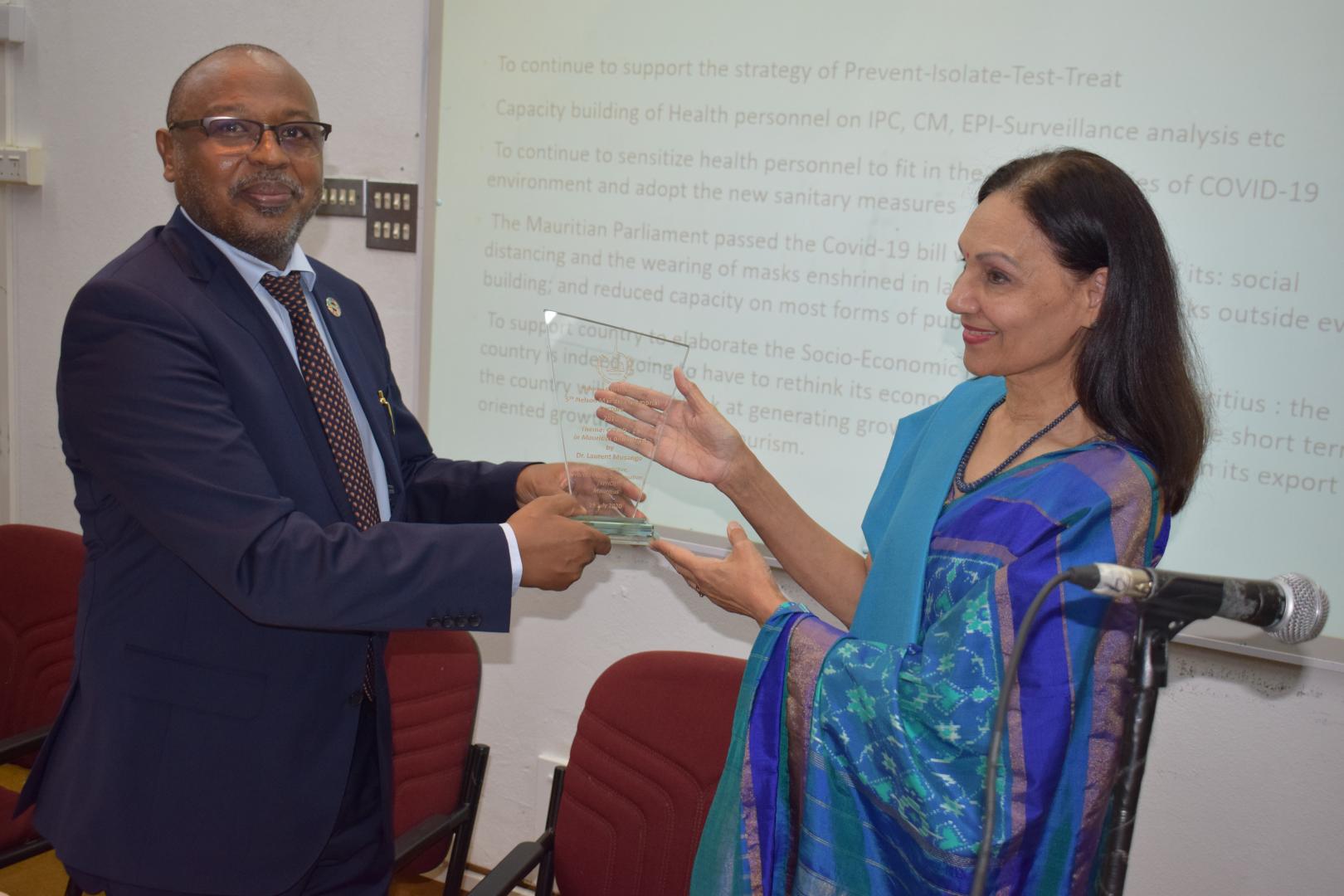 Dr L.  Musango, WHO Representative in Mauritius receiving a shield from Mrs S. Nirsimloo-Gayan, Director General of the Mahatma Gandhi Institute, Moka, Mauritius
