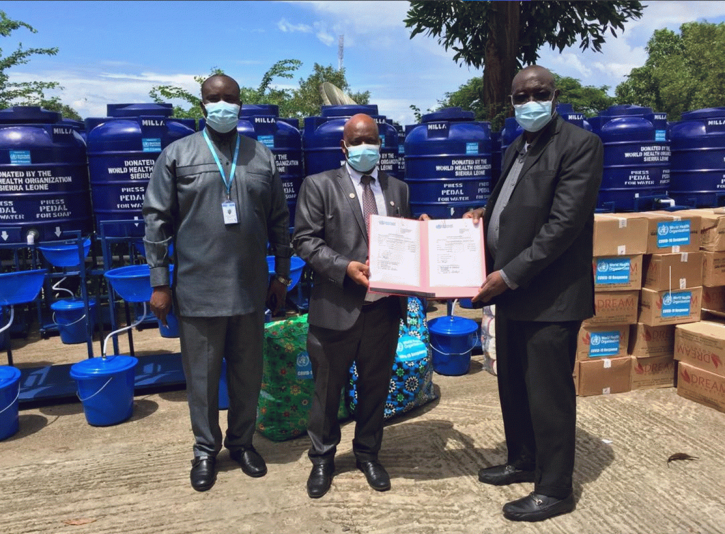 Dr Shongwe, WHO Representative, centre, handing over the certificate of donation to the Prof Gbakima, Minister of Technical and Higher Education