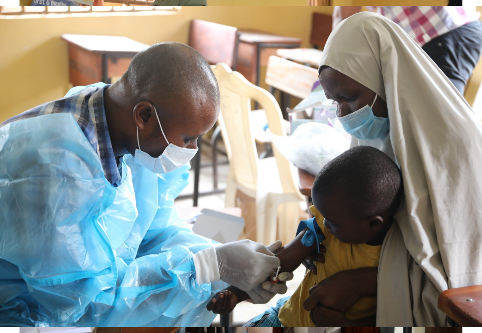 Health worker collecting blood sample for malaria test from one of Zulahatu Ibrahim’s children