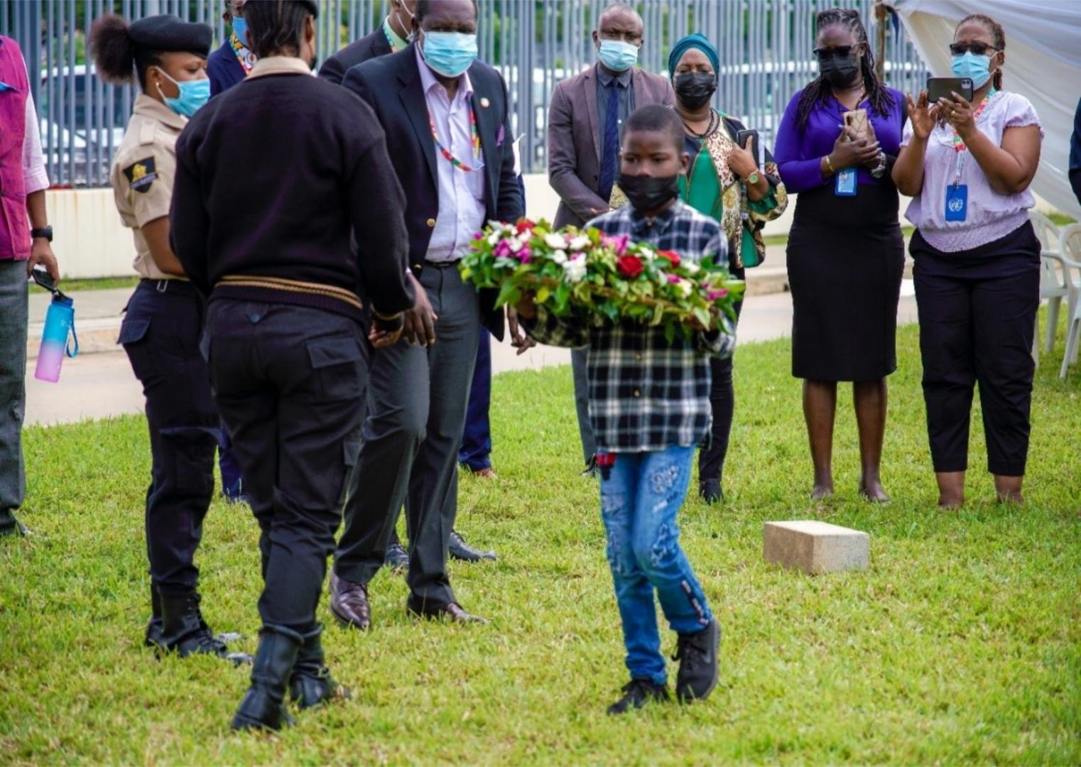 Son of one of the deceased laying wreaths in honor of his father