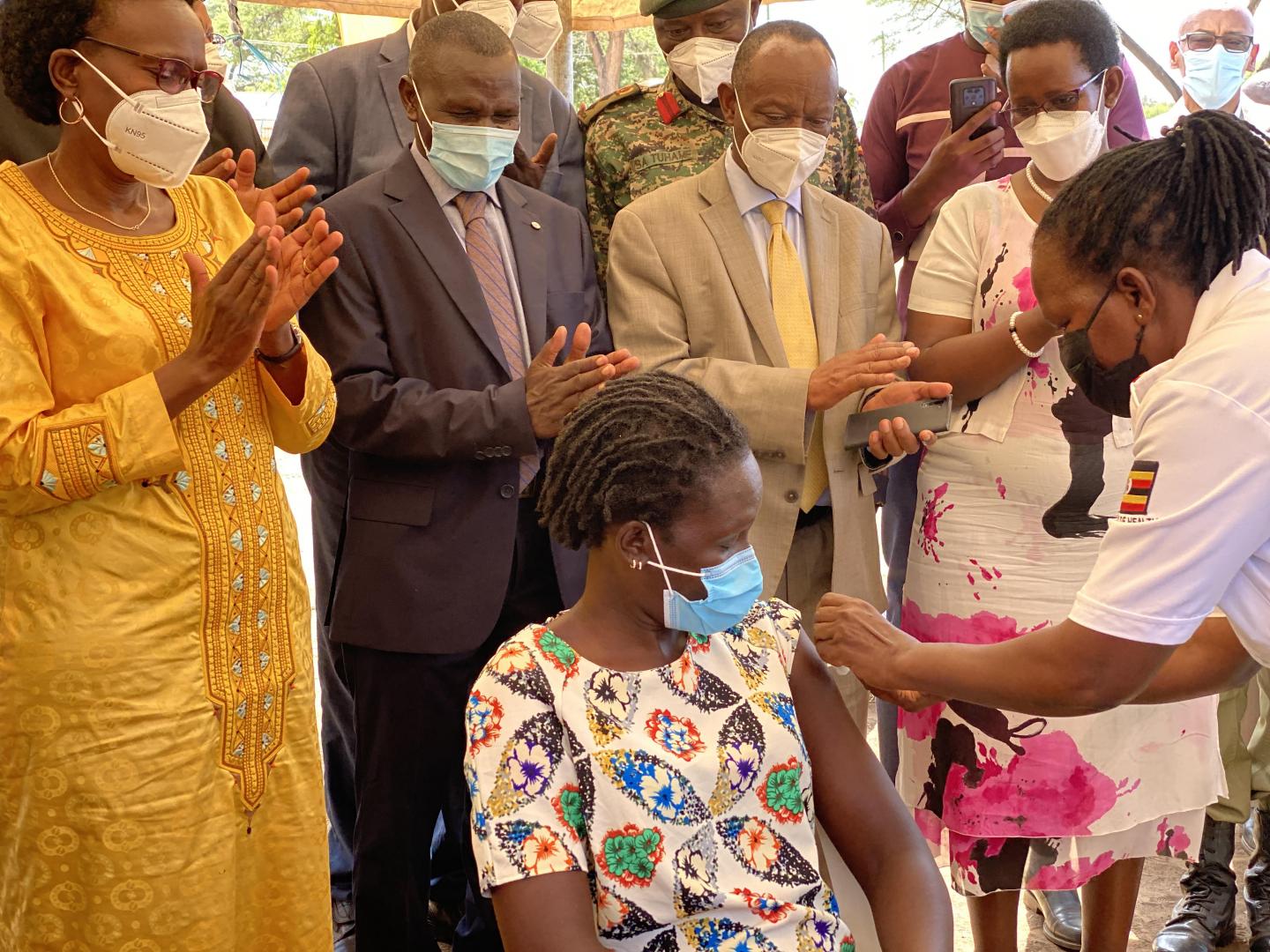 Ministry of Health leadership and partners led by the Minister of Health Hon Dr Jane Ruth Achieng (yellow) observe as a community member receives her COVID-19 vaccine shot at the launch in Moroto District. ©WHOUganda