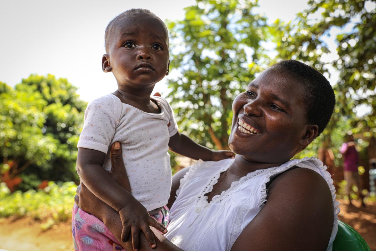 Odala Phiri holds her daughter Happiness Mark as the vaccinator administers the polio vaccine