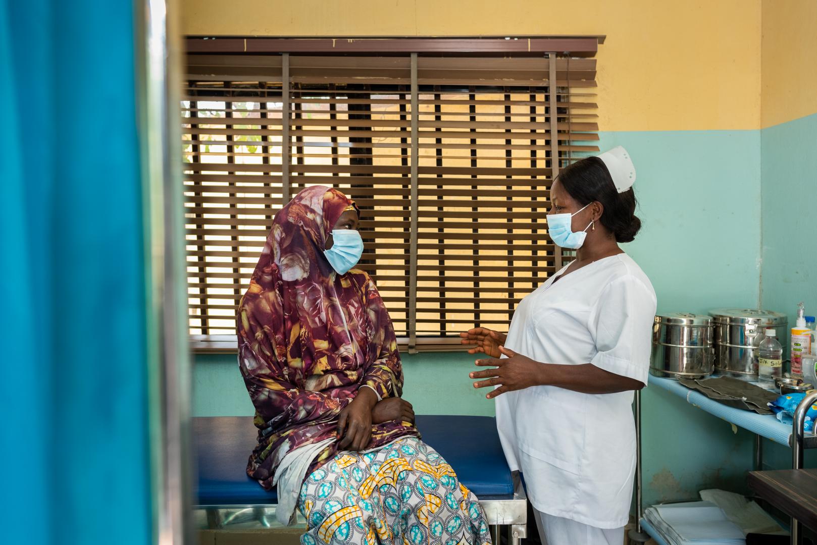 Nurse Peace (right) counsels a patient before she gets screened for cervical cancer at the RAiSE Foundation office in Niger State on 24 February 2021.