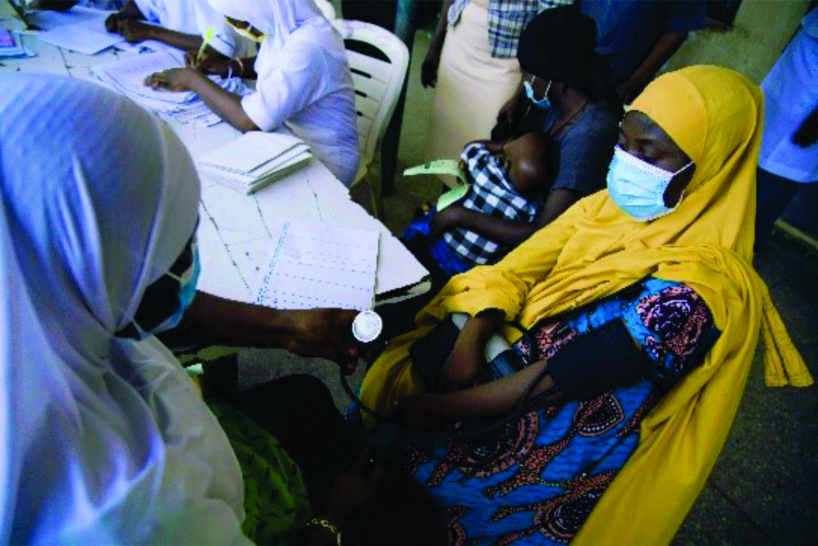 A health worker checking a patient’s blood pressure