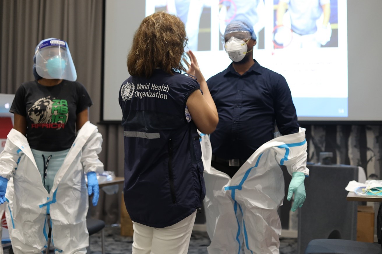 WHO facilitator leading a session on donning and doffing of personal protective equipment(PPE)