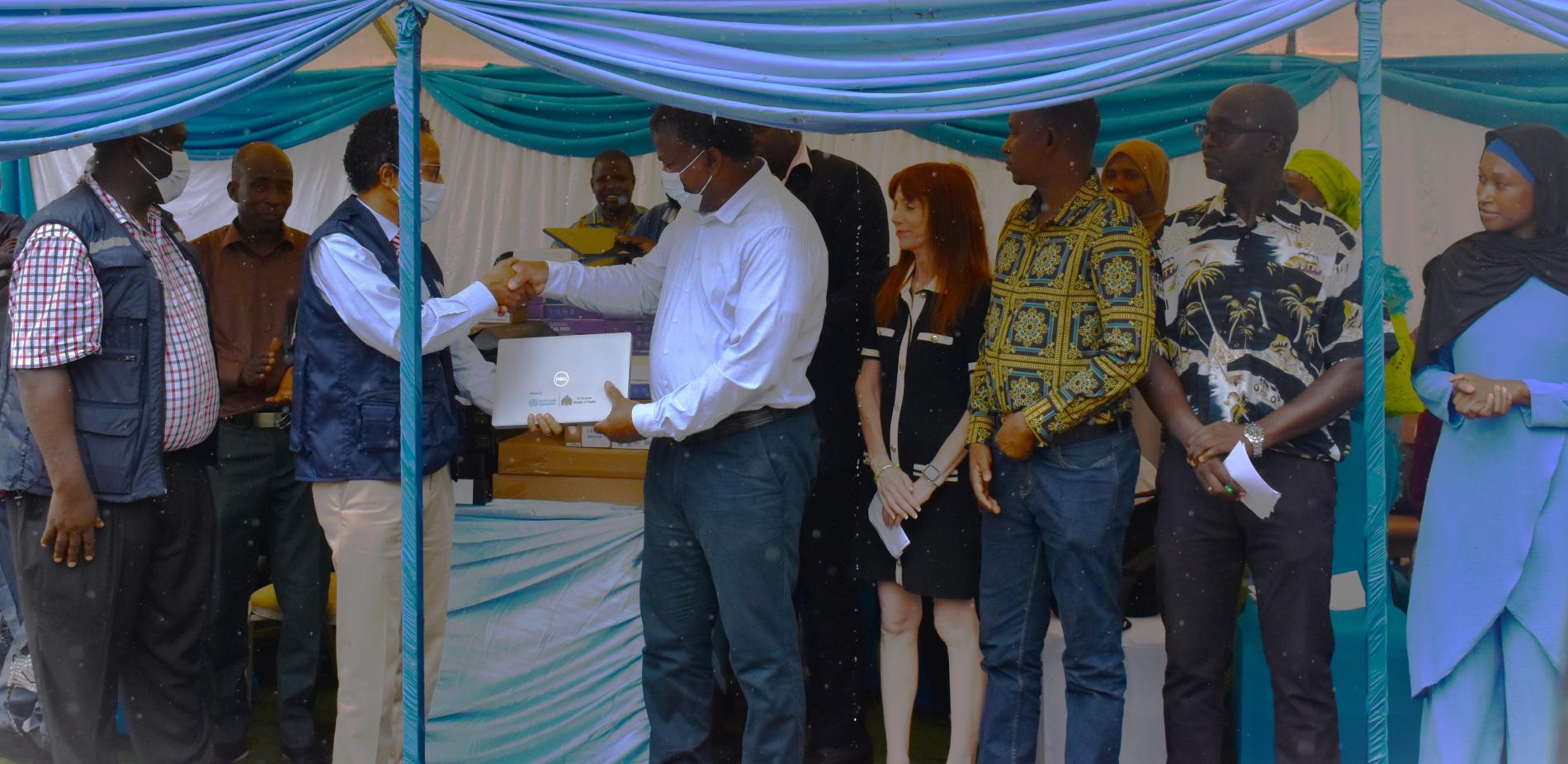 WHO Country Rep, Dr. Desta Tiruneh, presents the donations to Hon. Minister of Health, Dr. Ahmadou Lamin Samateh