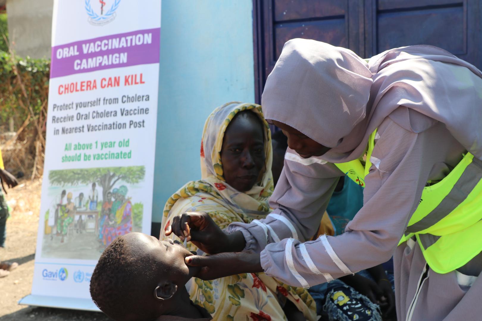 Healthcare worker administering oral cholera vaccine in Renk, South Sudan.