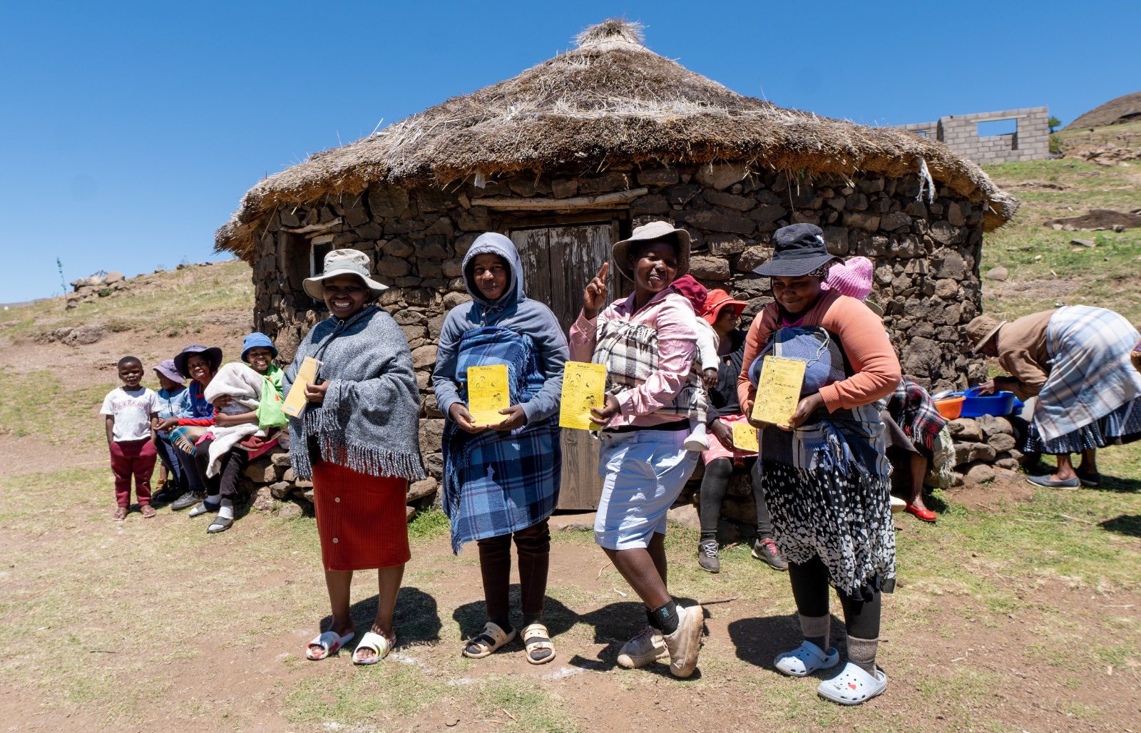 Parents from Mapholaneng community in Mokhotlong district displaying their children's vaccination card after participating in the MR campaign