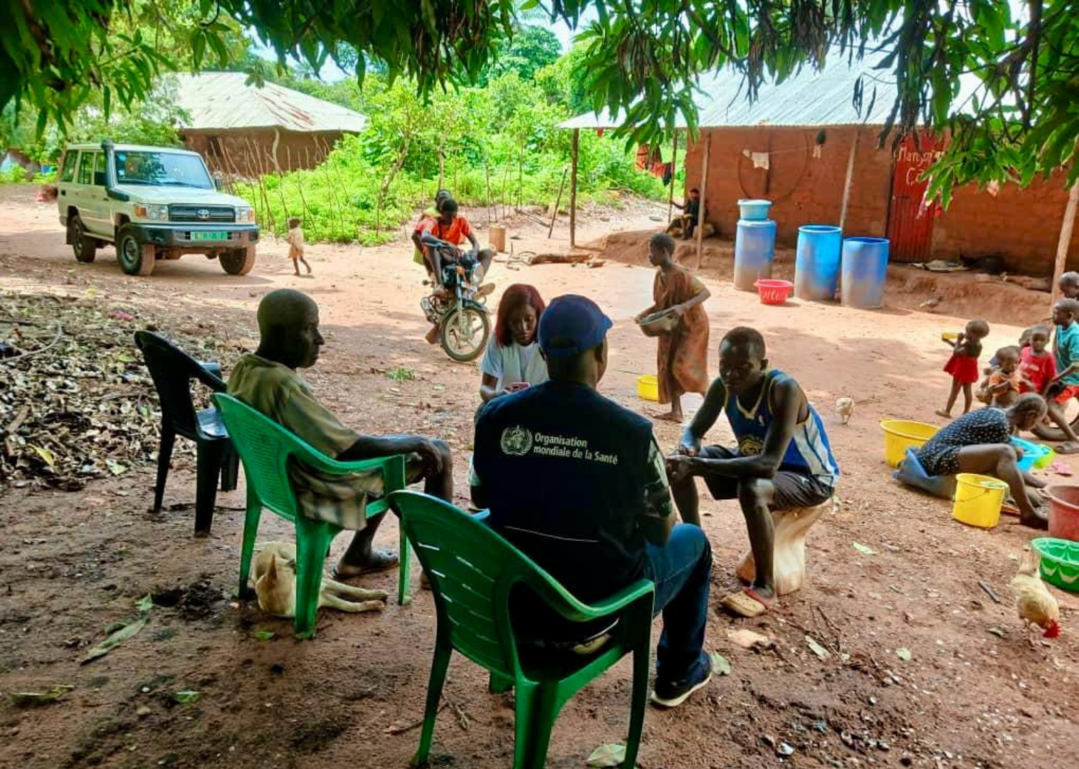 WHO staff member speaks with residents in a rural community.