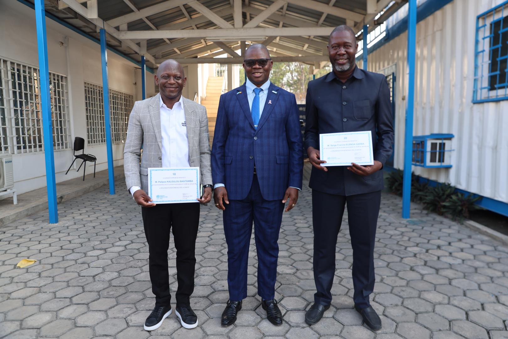Le Représentant de l'OMS au Congo, Dr Vincent Dossou Sodjinou (au milieu) avec les deux récipiendaires