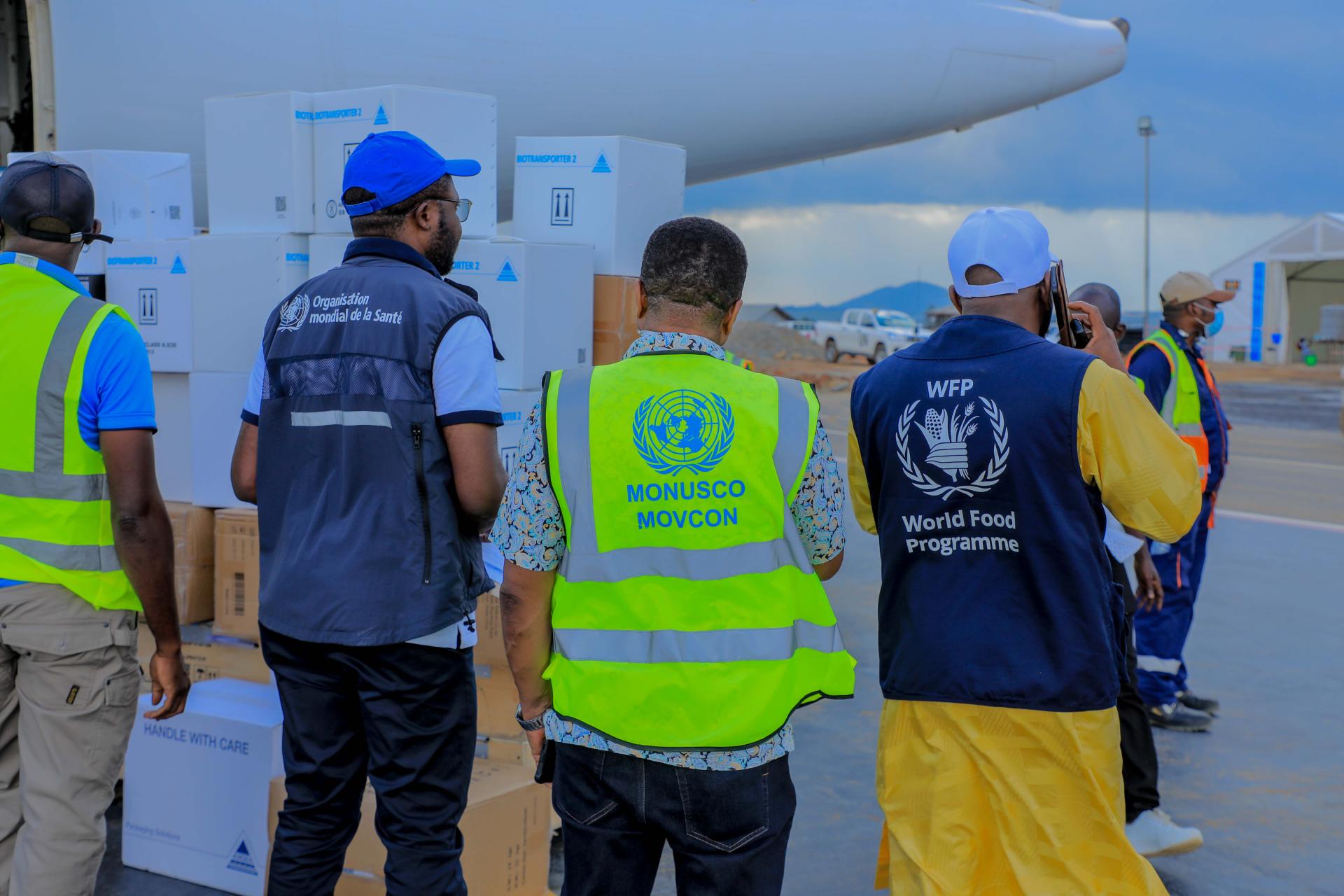 WHO, MONUSCO and WFP field staff coordinating on the tarmac