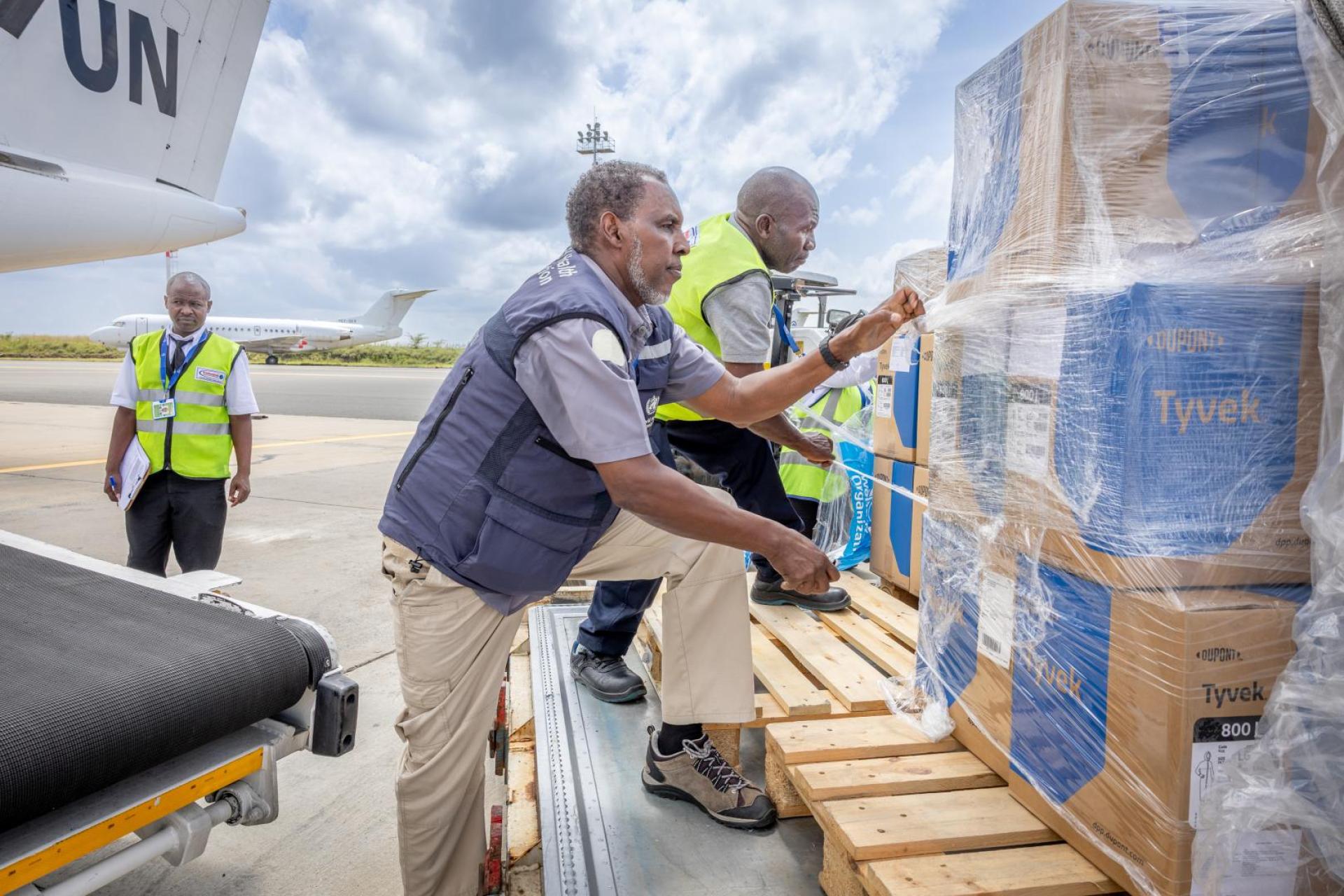 WHO and WFP field staff handling Tyvek personal protective equipment shipment