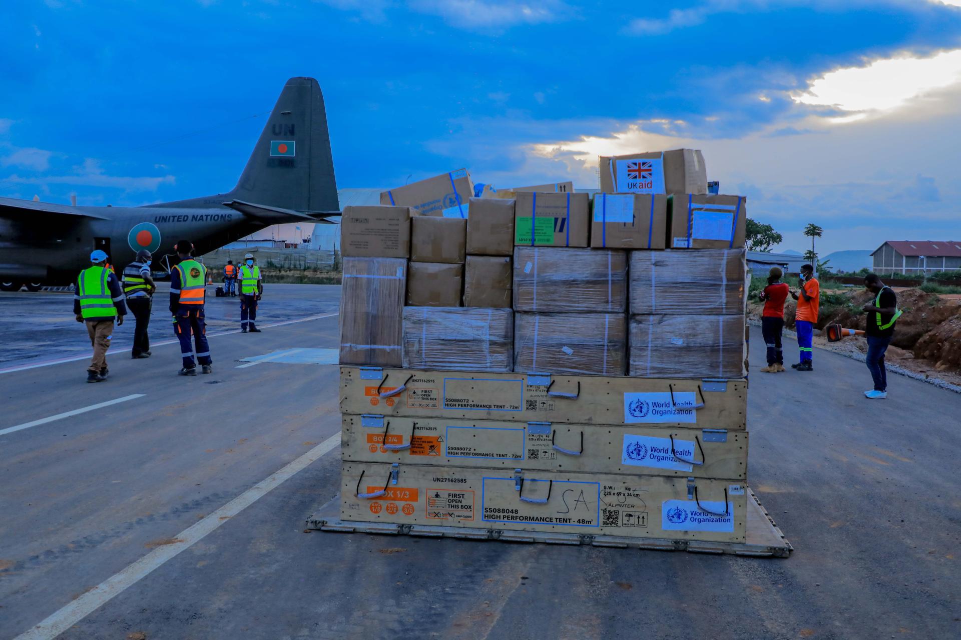 WHO emergency supplies on pallets in front of a UN cargo aircraft