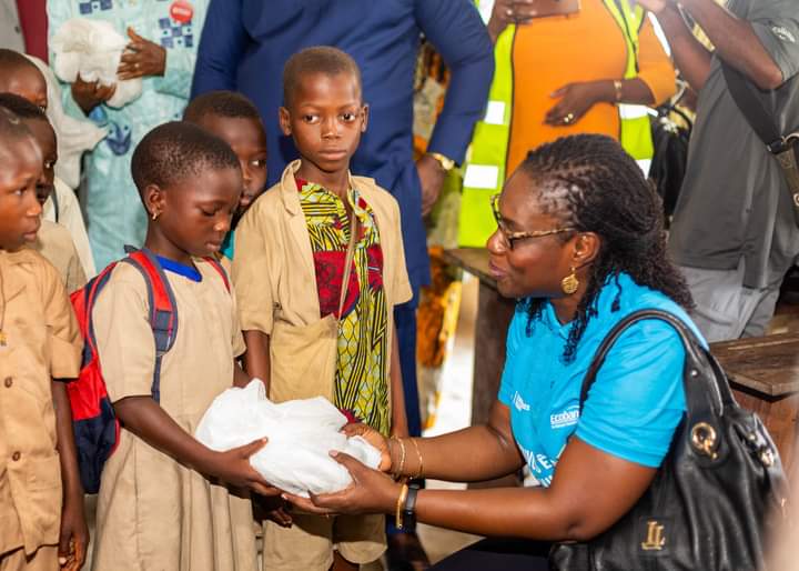 La Responsable de la Fondation Ecobanck Benin remettant une moustiquaire imprégnée aux écoliers de la cité lacustre de Ganvié