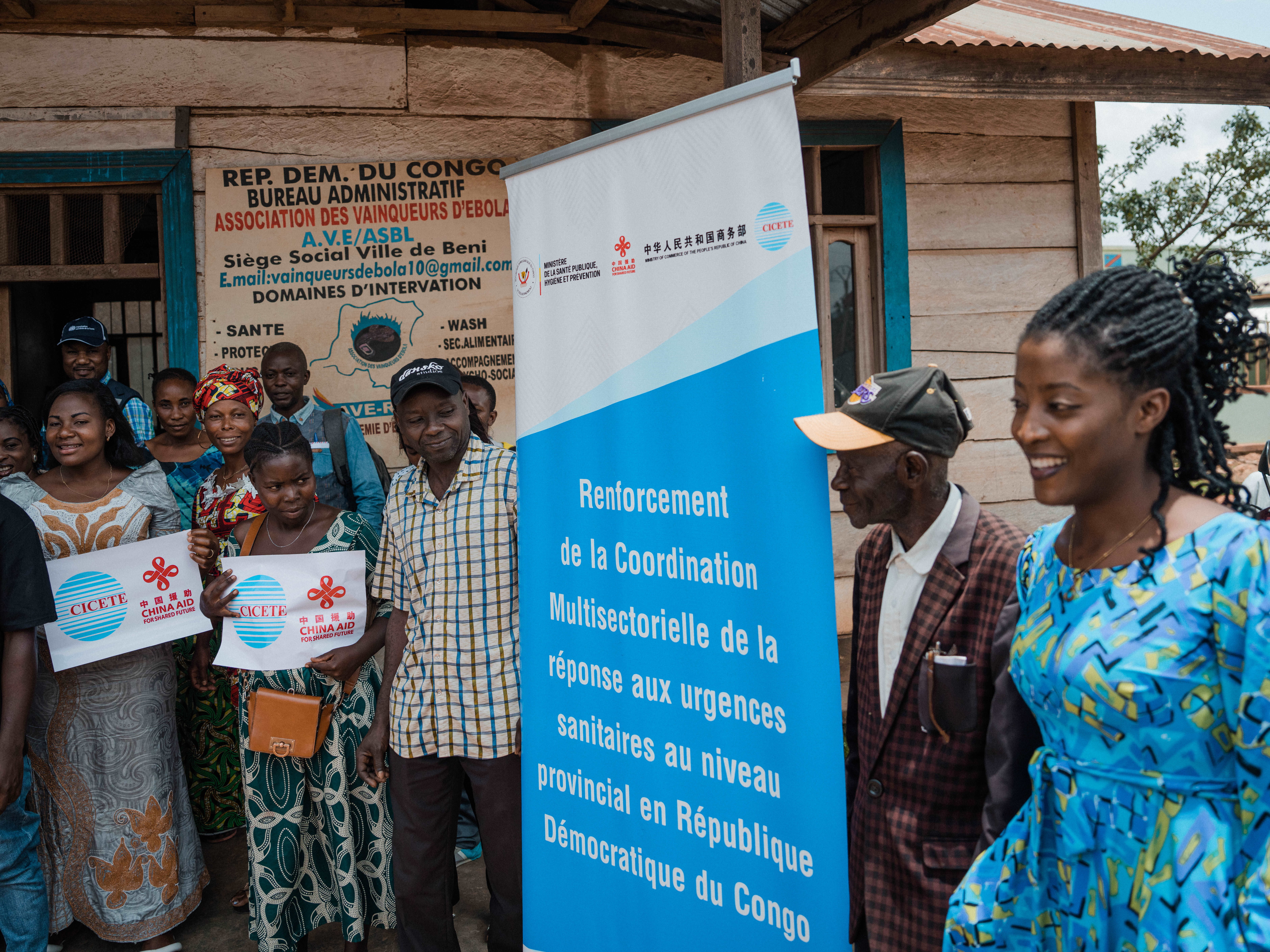 A droite, Elizabeth Zawadi, esquisse un sourire avant de poser avec ses autres collègues devant le siège de l’Association des vainqueurs d’Ebola, à Beni.  OMS/Hugh Cunningham Kinsella 