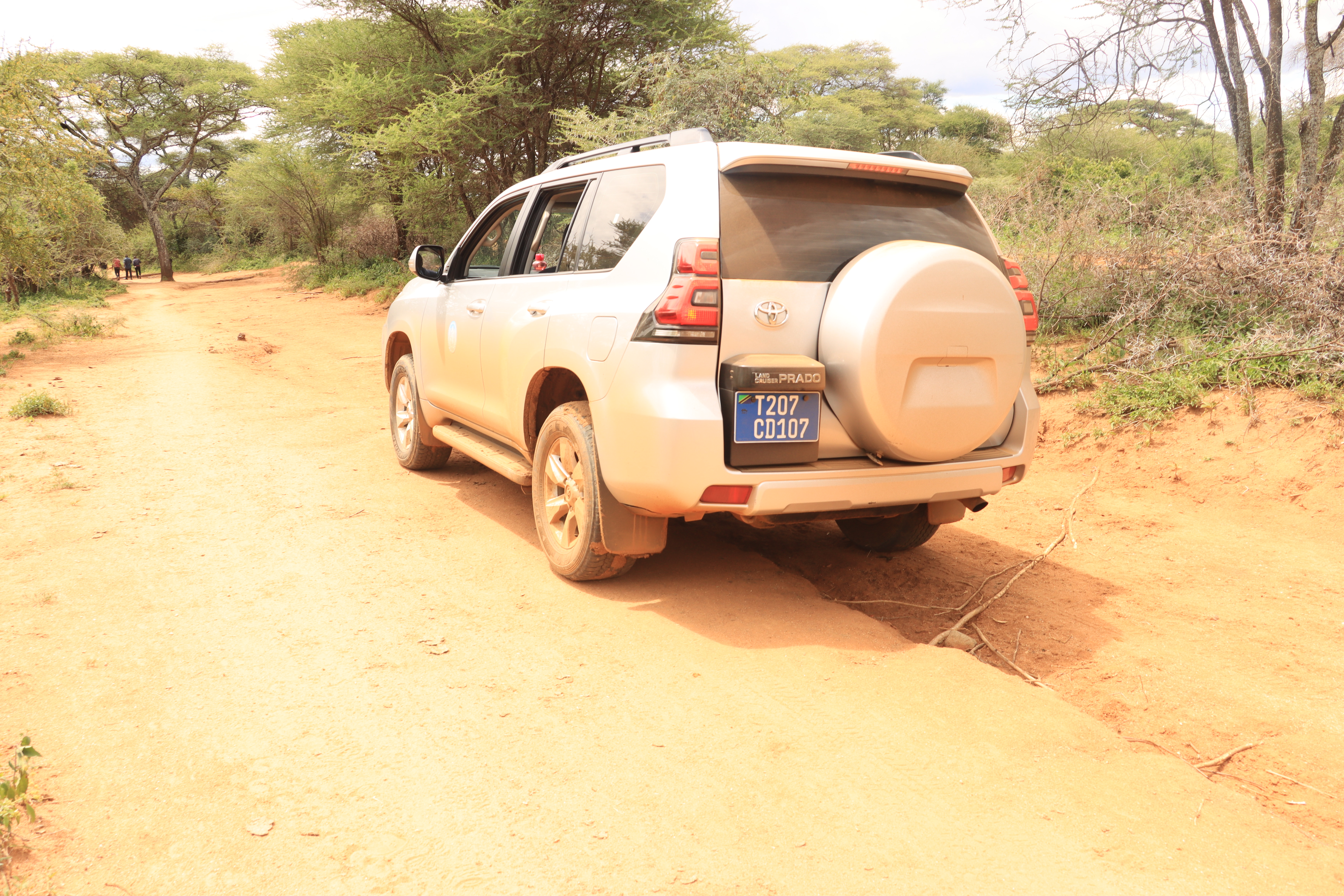 Vehicle passing one of the craggy paths to the Hadzebe family