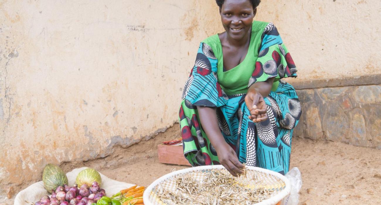 Marie Jeanne sits outside selling fruits and vegetables