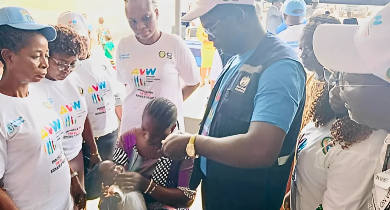 Figure 1A mother whose child is being vaccinated by a WHO staff as part of the commemoration of the African vaccination Week.png