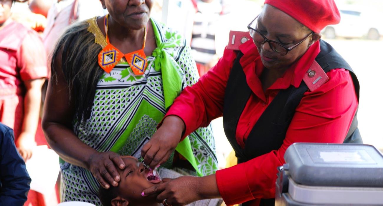 Health workers administering vaccines to children