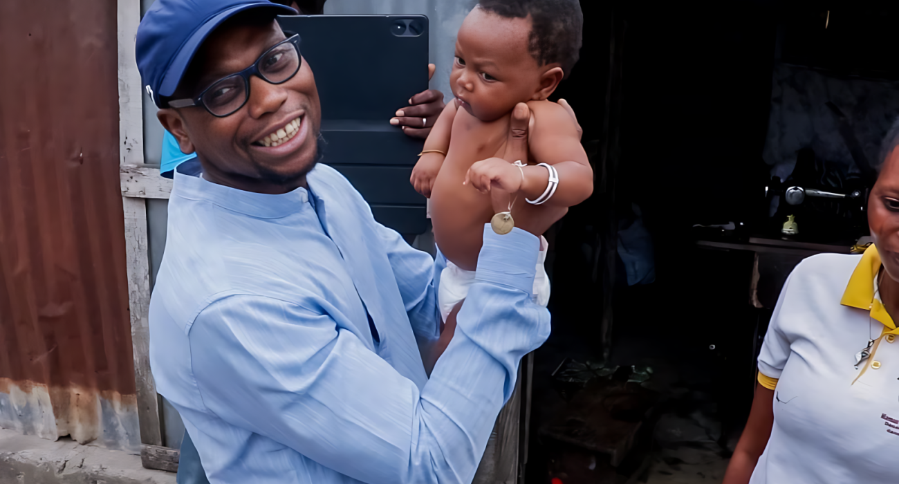 Le Ministre de la Santé Prof Benjamin Hounkpatin tenant un  enfant cible vacciné contre la Polio 