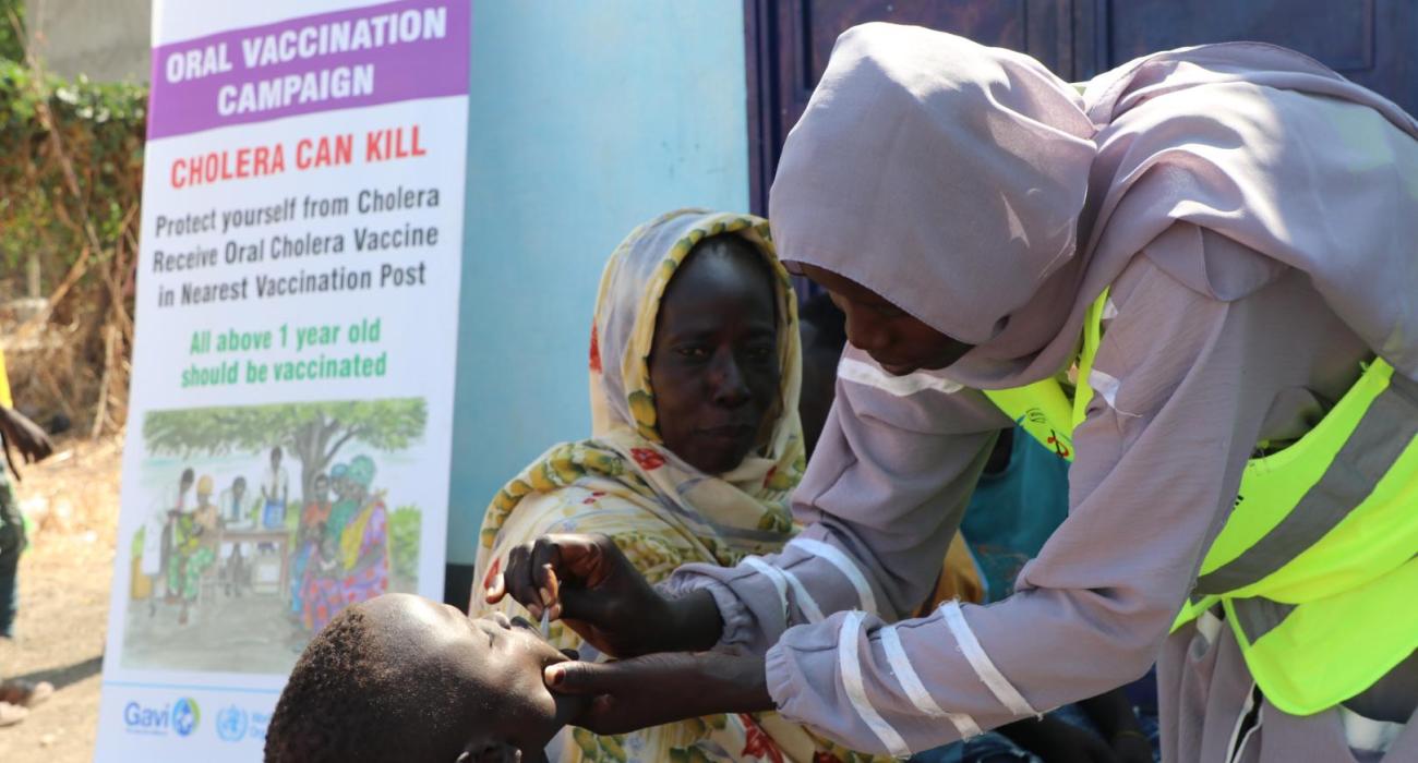 Healthcare worker administering oral cholera vaccine in Renk, South Sudan.