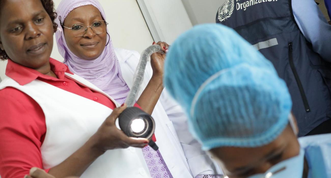 Dr Dille from WHO AFRO  looks on as the team conducts leep on a patient.