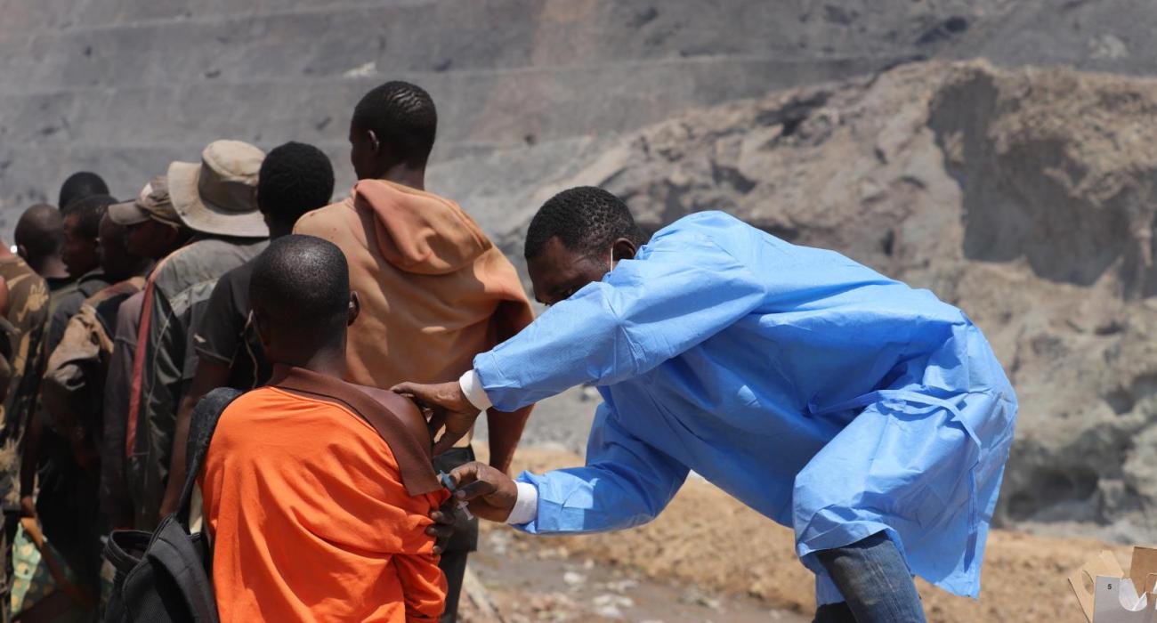 Dans l’ancienne mine à ciel ouvert de Tilwezembe, province du Lualaba (sud-est de RDC), des mineurs artisanaux reçoivent le vaccin contre la fièvre jaune, dans le cadre d’une campagne préventive. OMS/Vivian Nzabarinda