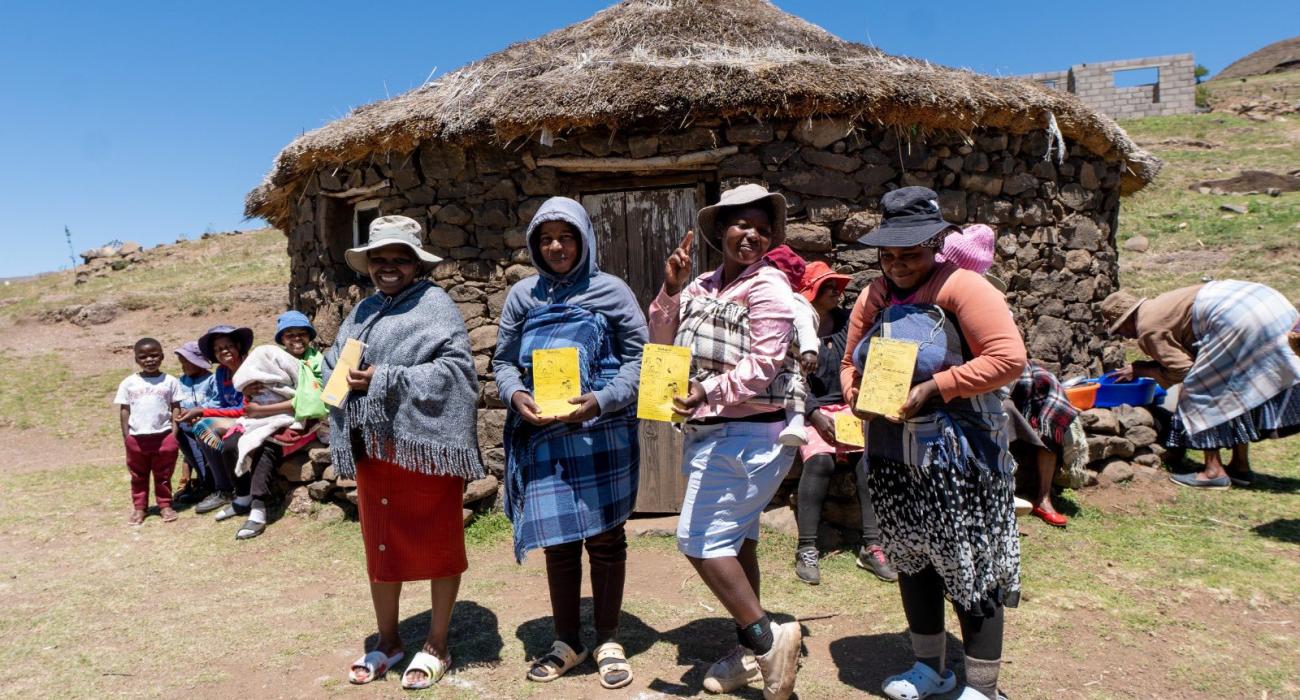 Parents from Mapholaneng community in Mokhotlong district displaying their children's vaccination card after participating in the MR campaign