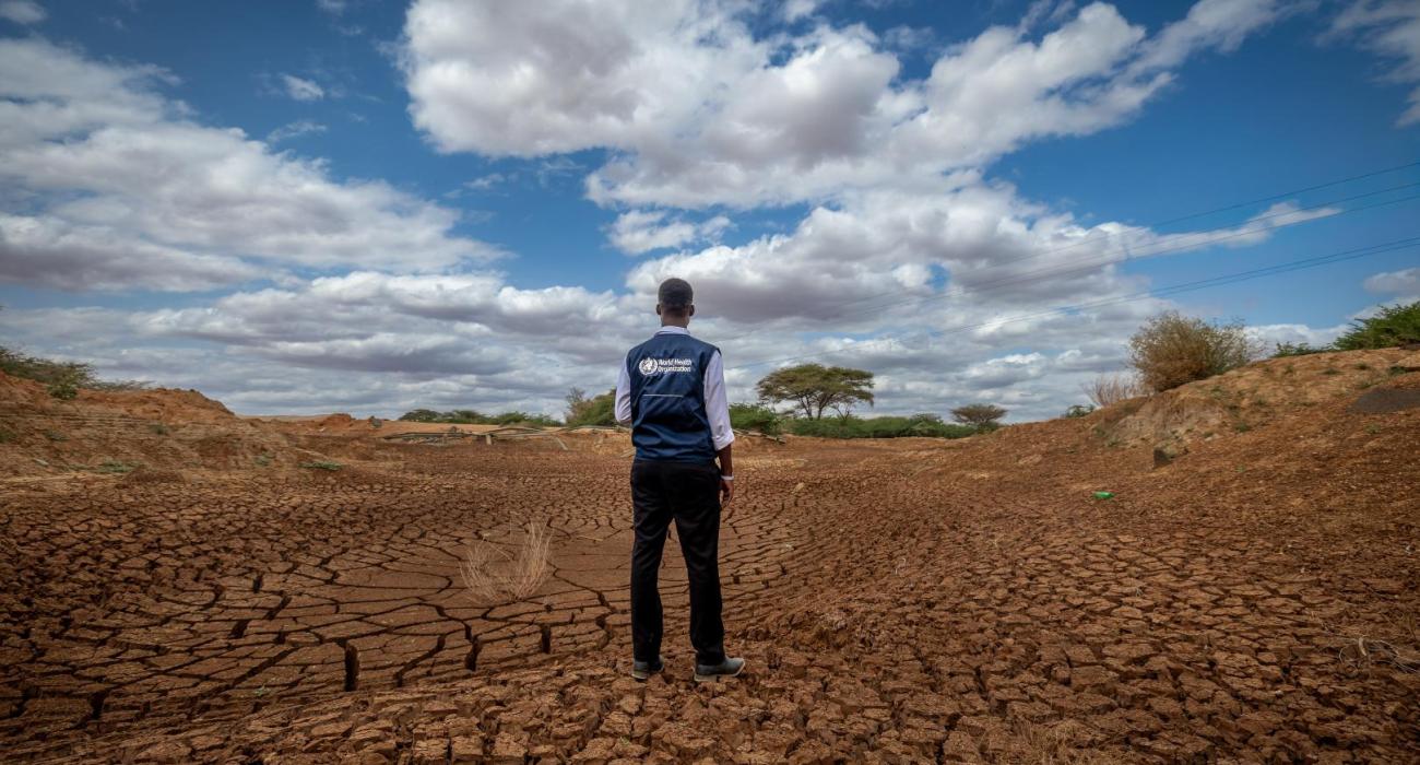Tillen Oduwo from WHO surveys a dried out river in Tula, Tana River County.