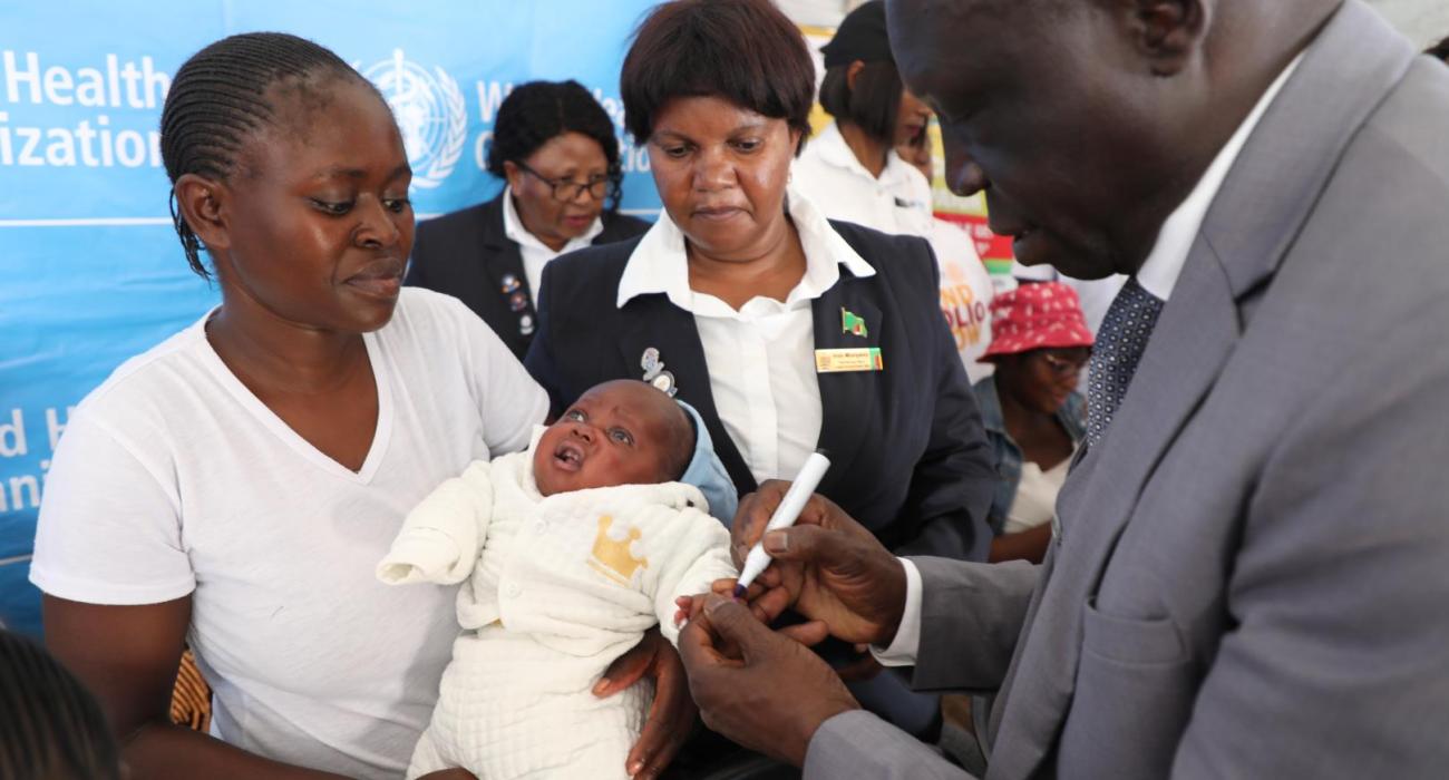 WHO Representative marking a vaccinated child