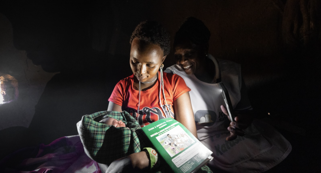 Neshoo Leaungokiok and her newborn baby, sits with Lucy Makena, a reproductive health officer from a nearby mobile outreach clinic supported by WHO. 