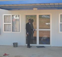 WHO Representative, Dr Charles Sagoe-Moses in front of the nearly completed isolation facility. 