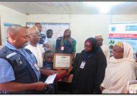 Presentation of plaque-certificate to widow of Late Isyaku Yakubu, by WHO State Coordinator in Niger State