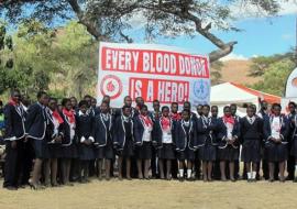 Some of the blood donors in front of the banner