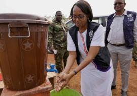 Dr Moeti washes her hands at the entrance of the District Emergency Response center in Port Loko, Sierra Leone. WHO / P. Desloovere