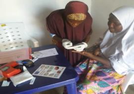 Midwife doing routine malaria Rapid Diagnostic Test (RDT) screening to a pregnant woman as an Ante-Natal Care service in Garba Buzu IDP Camp MdM