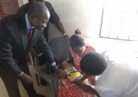 The permanent secretary of Abia State ministry of health supporting a health worker to vaccinate a 14-week-old baby with IPV