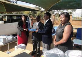 Dr Beatrice Mwagomba handingover a blood pressure machine to the Dr Nkambule, DHO Kasungu standing second left
