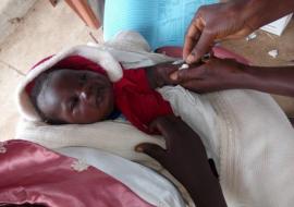 03 - A child being vaccinated against measles in Laniya
