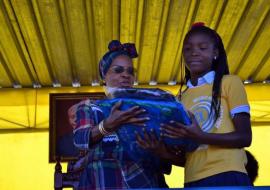 Dra Maria da Luz Dai Guebuza, fazendo a entrega à vencedora do concurso sobre a malária denominado: Sopa de Letras e Cultura Geral