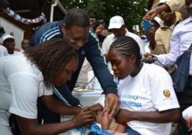 Minister of Health, Dr. Alexandre Manguele, giving the first PCV-10 vaccine to 2-months old Omar Octavio