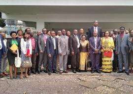 Photo de famille comprenant le Représentant de l’OMS en RDC, le Secrétaire général à la Santé Publique, l’ancien Basketteur de la NBA, Mutombo DIKEMBE et les autres participants à la réunion conjointe sur la lutte contre le cancer du col de l’utérus en RDC, devant la salle de conférence de l’OMS, à Kinshasa