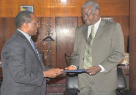De droite à gauche : Le Ministre des Affaires Étrangères et de l’Intégration Africaine recevant des mains du nouveau Représentant de l’OMS les lettres de créance.