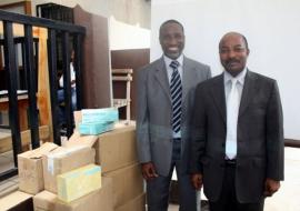 De G à D, le Dr Abdoulaye Yam, EPI et le Dr Désiré Lassegué, SGA à côté du lot de consommables pour le laboratoire offert par l’OMS