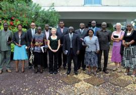 Photo des participants à la réunion d’évaluation à mi-parcours OMS-USAID devant la salle de conférence de l’OMS