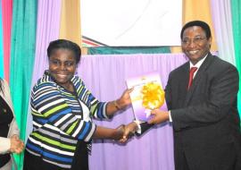 WHO Officer, Dr Joyce Nato receives the launched strategy document from DMS Dr Jackson Kioko