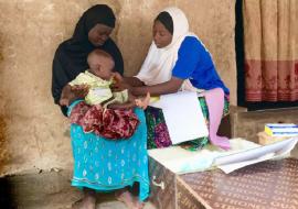 Miriam, a community health worker, diagnoses a sick child and provides treatment medicines/ Photo: WHO/C. Kane Miriam, a community health worker, diagnoses a sick child and provides treatment medicines/ Photo: WHO/C. Kane