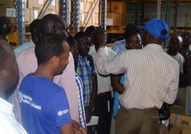 WHO Logistics Officer showing various emergency kits at the WHO central warehouse