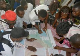 Les participants à l'atelier  de cartographie participative  en pleine discussion sur les mouvements de la population à Mbandaka aux points de passage et rassemblement importants. OMS/Eugene Kabambi 