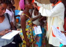 A health worker administers the Cholera vaccine to a mother in Hoima District 